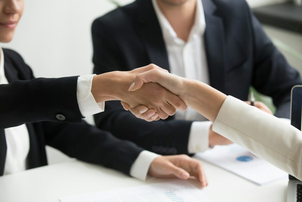 Handshake after a business meeting, illustrating choosing a real estate marketing agency