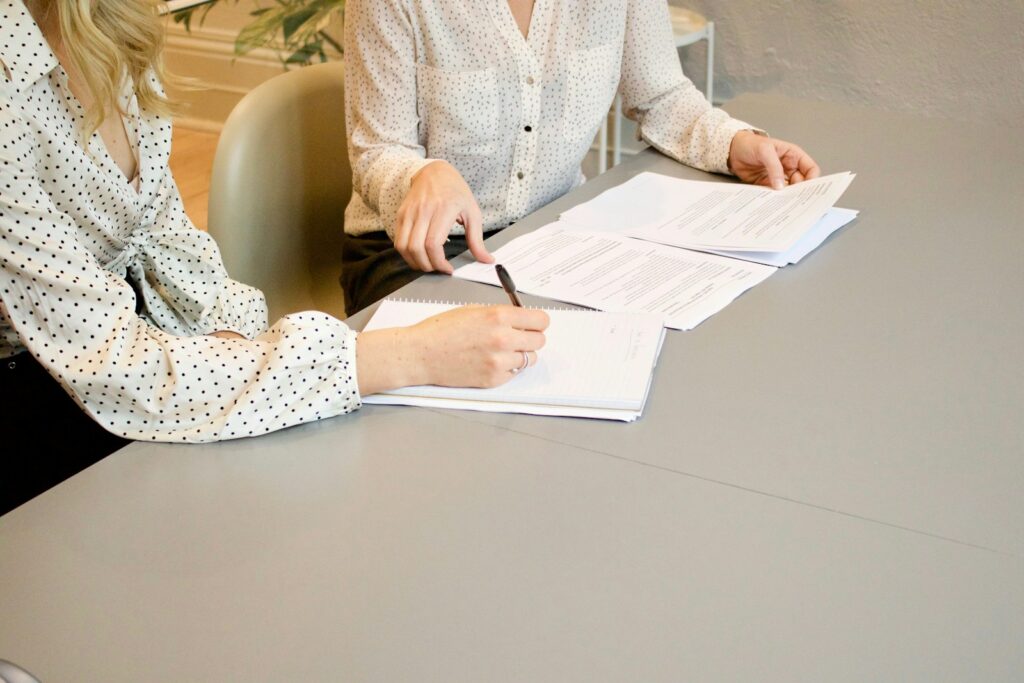 Property agent signing registration papers at an office desk