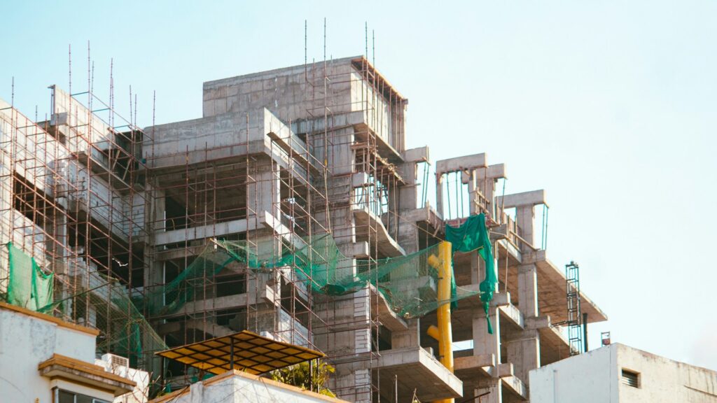 Building under construction with scaffolding, the progress a haryana rera qpr reports